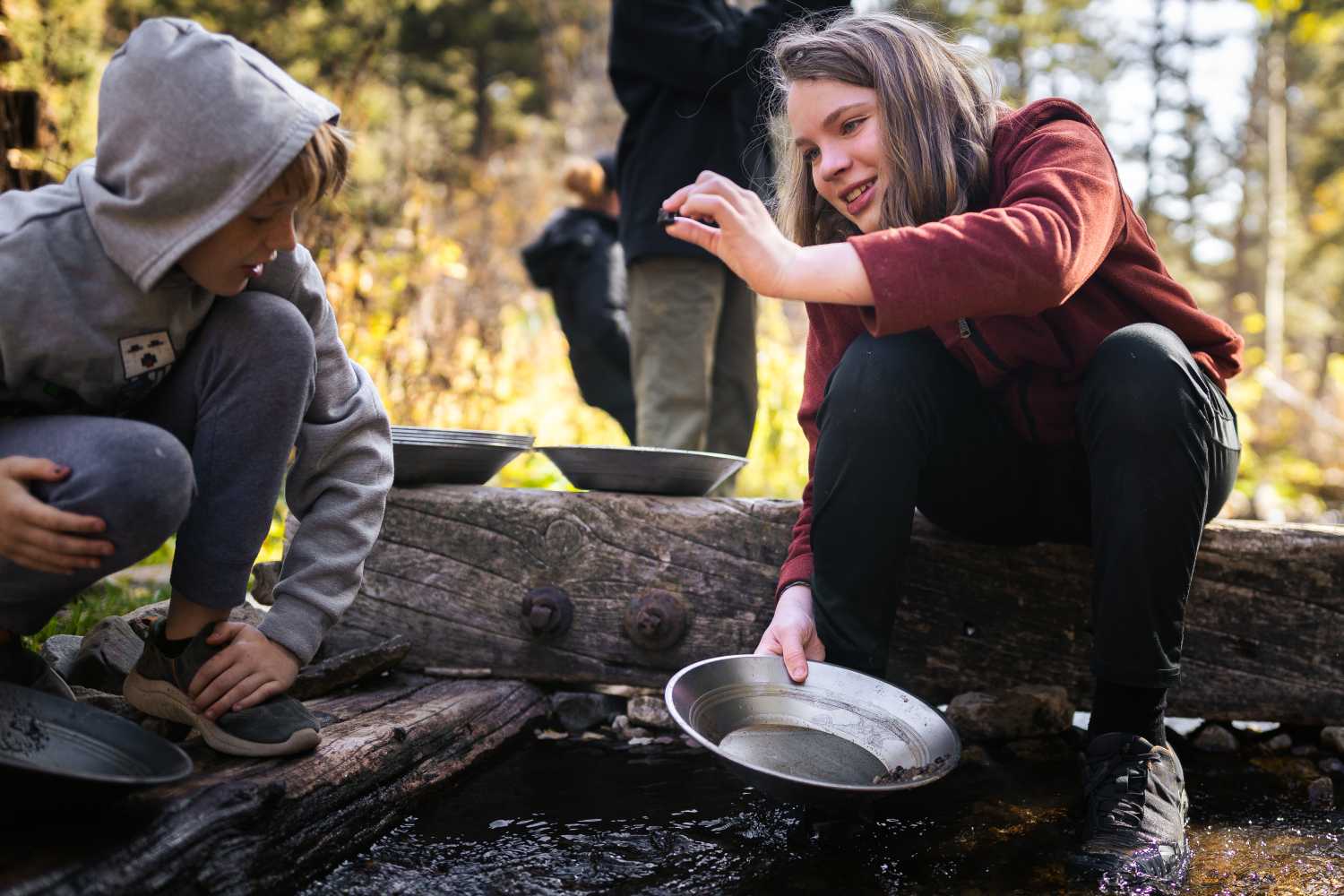 Two young scouts sit together while holding pans